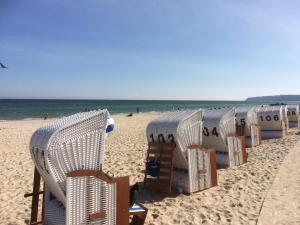 a row of lawn chairs on the beach at Ferienwohnung Ostsee-Buhne Baabe in Baabe +2 photos