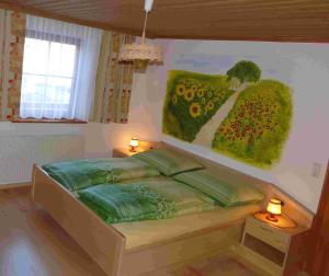 - une chambre avec un lit orné d'une peinture murale dans l'établissement Haus Edelweiss, à Sankt Margarethen im Lungau