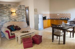 a living room with a couch and a table and a kitchen at Lharmonie Villa in Pereybere