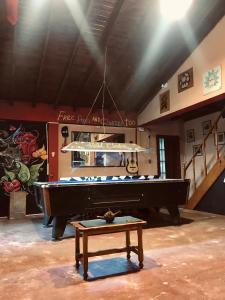uma mesa de bilhar num quarto com um piano em El Carretero em Ushuaia