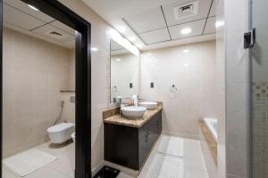 a bathroom with two sinks and a toilet and a mirror at Balqis Residense Palm Jumeirah,Pool, Beach, Top floor, Full sea view, Restaurants in Dubai
