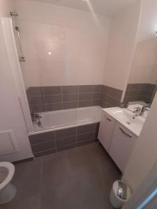 La salle de bains est pourvue d'une baignoire, d'un lavabo et de toilettes. dans l'établissement charmant appartement en plein coeur de Trouville, à Trouville-sur-Mer