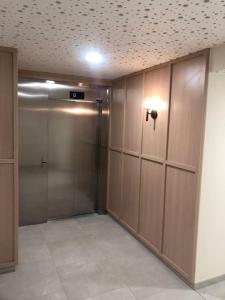 a room with a elevator with wooden doors and tile floors at charmant appartement en plein coeur de Trouville in Trouville-sur-Mer