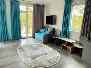 a living room with a blue couch and a tv at Отель MONBLAN in Yablunytsya
