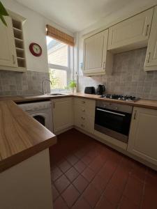 uma cozinha com armários brancos e um forno com placa de fogão em Liverpool Victorian Townhouse - 3 Bedrooms em Liverpool