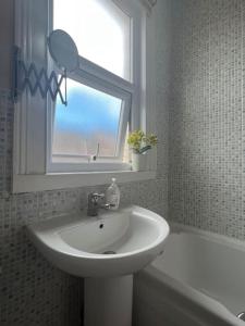 a white bathroom with a sink and a window at Liverpool Victorian Townhouse - 3 Bedrooms in Liverpool