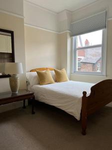 a white bedroom with a bed and a window at Liverpool Victorian Townhouse - 3 Bedrooms in Liverpool