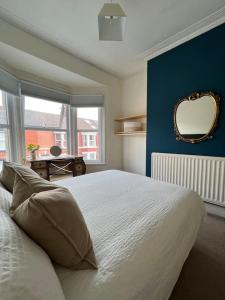 a bedroom with a bed with a mirror and a window at Liverpool Victorian Townhouse - 3 Bedrooms in Liverpool