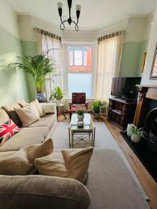 a living room with a couch and a tv at Liverpool Victorian Townhouse - 3 Bedrooms in Liverpool