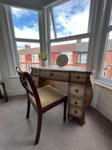 Liverpool Victorian Townhouse - 3 Bedrooms في ليفربول: مكتب مع كرسي أمام النافذة