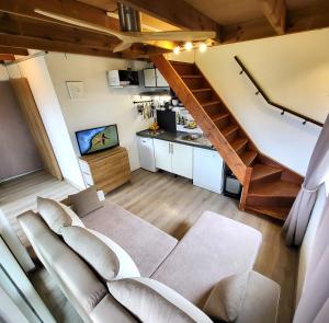 ein Wohnzimmer mit einem Sofa und einer Treppe in der Unterkunft Tiny House Chaleureuse au Style Contemporain Minimaliste in Le Tampon