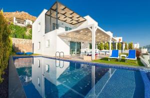 a villa with a swimming pool in front of a house at Bodrum Horizon Villas in Bodrum City