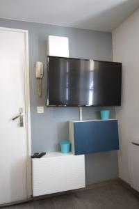 Habitación con TV en la pared en Cosy Apartment In The Center Of La Flotte, en La Flotte