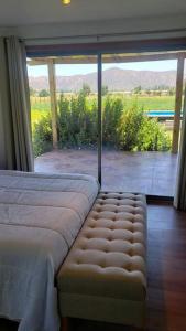 a bedroom with a bed and a large glass window at Casa de Campo Viña el Campesino con Tinaja Caliente y Piscina in Melipilla