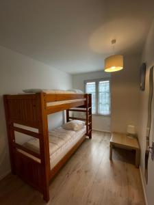 a bedroom with two bunk beds and a table at Nice 120m with garden near the sea in Sainte-Marie-de-Ré