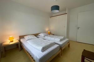 two beds in a room with two lamps on tables at Nice 120m with garden near the sea in Sainte-Marie-de-Ré