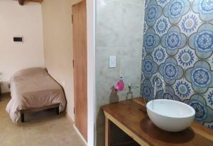 a bathroom with a sink and a room with a bed at Cabañas Pucara Taki in Tilcara