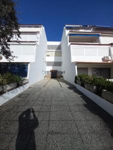 une ombre d'une personne prenant une photo d'un bâtiment dans l'établissement Apartamento moderno frente a la playa San Miguel, à El Rompido