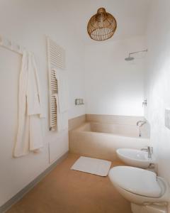 a bathroom with a toilet and a sink and a tub at Palombara Masseria & SPA - Adults Only in Oria