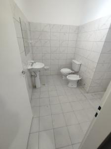 a white bathroom with two toilets and a sink at Hosteria de Anquincila in Anquincila