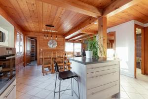 a kitchen with wooden ceilings and a dining room at Les Picaillons - Le gîte in Les Villards-sur-Thônes