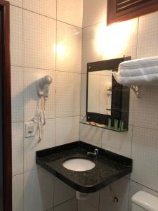 uma casa de banho com um lavatório e um espelho em Pousada Murici em Barreirinhas
