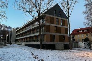 un edificio con nieve en el suelo delante de él en Apartmán Betula-apartmán v srdci Vysokých Tatier, en Vysoké Tatry