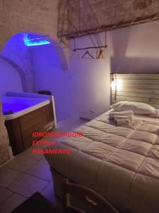 sypialnia z dużym łóżkiem z niebieskim światłem w obiekcie Dimora 'a Petr - Suite 'a Petr w mieście Ceglie Messapica