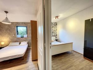 1 dormitorio con 2 camas y ventana en Appartement bucolique proche Rennes et Brocéliande, en Saint-Thurial