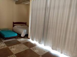 sypialnia z łóżkiem i oknem z zasłonami w obiekcie Amplo Loft integrado com vista para montanhas! w mieście Itanhandu