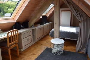 a bedroom in a attic with a bed and a window at Petit duplex de charme sous les toits du Mont-Dore in Le Mont-Dore