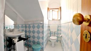 a small bathroom with a sink and a toilet at Hospedaria Pielas in Sintra