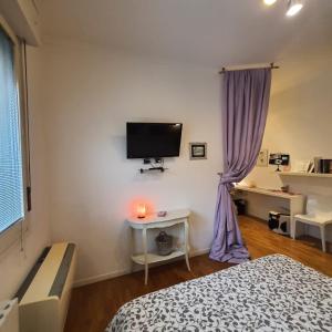 um quarto com uma cama e uma televisão na parede em Zer051 Apartment Dossetti 23 em Bolonha
