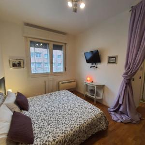um quarto com uma cama, uma televisão e uma janela em Zer051 Apartment Dossetti 23 em Bolonha