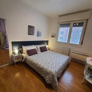 um quarto com uma cama e duas janelas em Zer051 Apartment Dossetti 23 em Bolonha