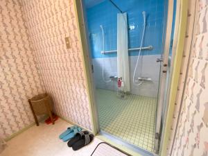 ein Bad mit einer Dusche und einer Glastür in der Unterkunft 浜町小院 Guest House in Takamatsu