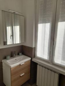baño con lavabo, espejo y ventana en Casa Vacanza "Aurora", en Costa Volpino