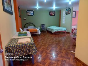 Pokój z 2 łóżkami w pokoju z drewnianą podłogą w obiekcie Casa Familiar Eventos y Recepciones Huanchaco Huanchaquito w mieście Huanchaco