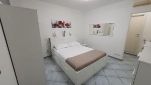 a bedroom with a bed in a white room at Residenza La Gazza e Spiaggia in Cervia