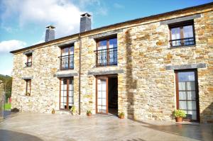 a large brick building with windows on it at El Castro de Oscos 