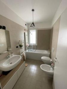 bagno con 2 lavandini, vasca e servizi igienici di Boutique Apartment a Pescara
