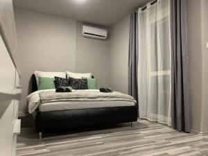 1 dormitorio con cama y ventana en Backyard Apartment, en Miskolc