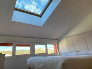1 dormitorio con 1 cama y 3 ventanas en Vivienda turística Los Tejados en Soria