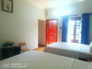 - une chambre avec 2 lits et une porte rouge dans l'établissement Tamcoc Mr. Cau Homestay, à Ninh Binh