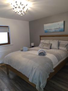 1 dormitorio con 1 cama grande y lámpara de araña en The Dingle Galley, en Dingle
