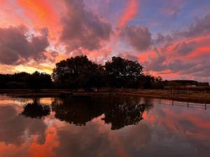 una puesta de sol sobre un cuerpo de agua con un cielo nublado en Carpe Diem - Le Domaine Wambrechies, en Wambrechies