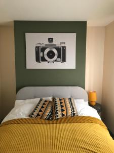 a picture of a camera on a green wall above a bed at Cosy 3 bedroom house close to beach in Lowestoft