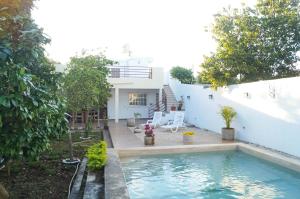een zwembad voor een wit huis bij Hotel Monserrat in Mérida