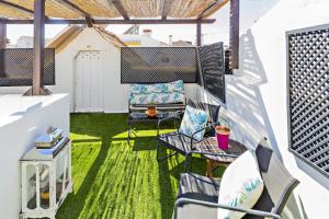 a balcony with green grass and chairs and a table at Apartamentos da Cidade in Tavira