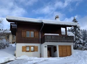 Una casa con nieve en el techo. en Chalet Le Renard Du Lac en Les Gets